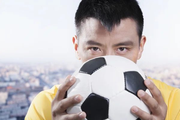 Fotbollsspelare hålla bollen mot hans ansikte — Stockfoto