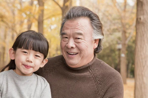 Grandfather and granddaughter in park — Stock Photo, Image