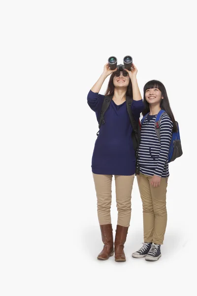 Mother looking through binoculars with daughter next to her — Stock Photo, Image