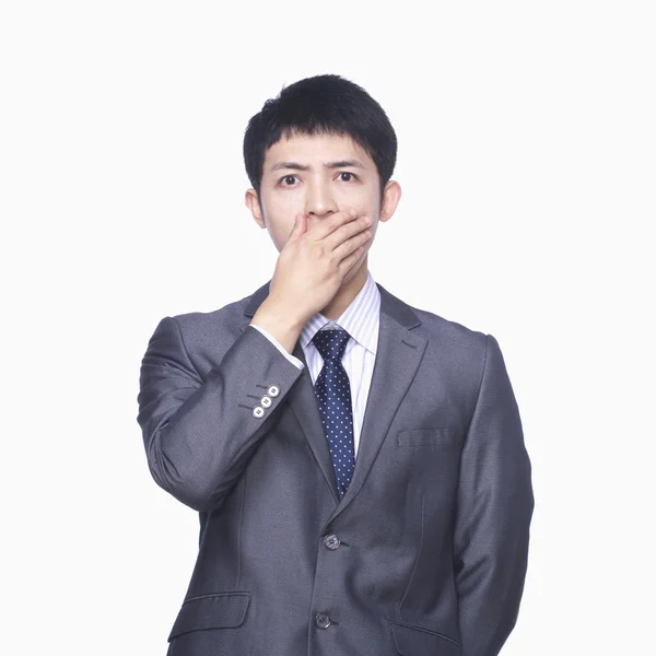 Businessman covering mouth with hand — Stock Photo, Image