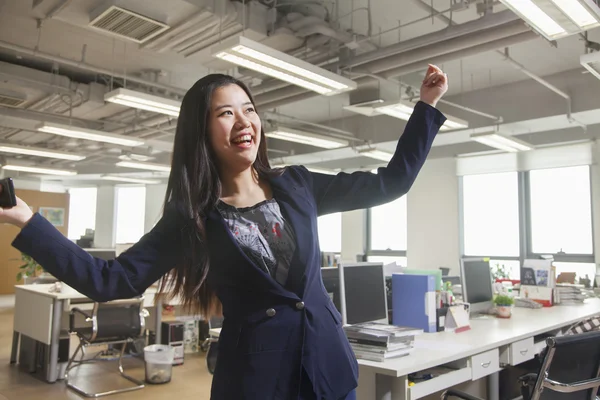 Empresária sorrindo com os braços levantados — Fotografia de Stock