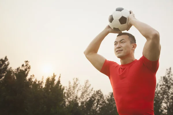 Homme lançant ballon de football — Photo