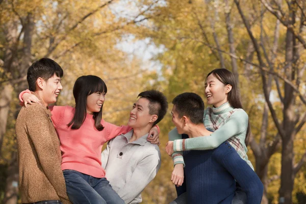 People playing piggyback in park — Stock Photo, Image