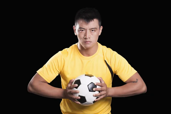 Jogador de futebol segurando bola no peito — Fotografia de Stock