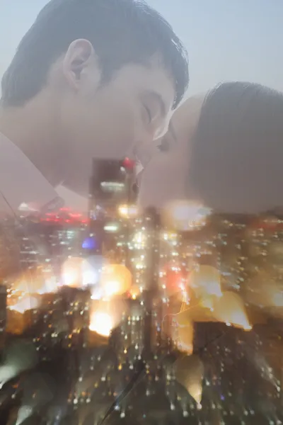 Doble exposición de pareja besándose durante la noche paisaje urbano — Foto de Stock