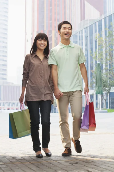 Caminhada de casal com sacos de compras — Fotografia de Stock