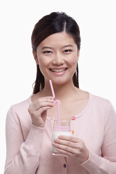 Mujer sonriendo y bebiendo un vaso de leche — Foto de Stock