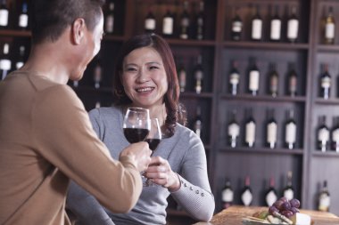 Olgun çift toasting ve kendilerini şarap içme zevk