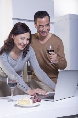 Mature Couple Looking at Laptop in the Kitchen clipart