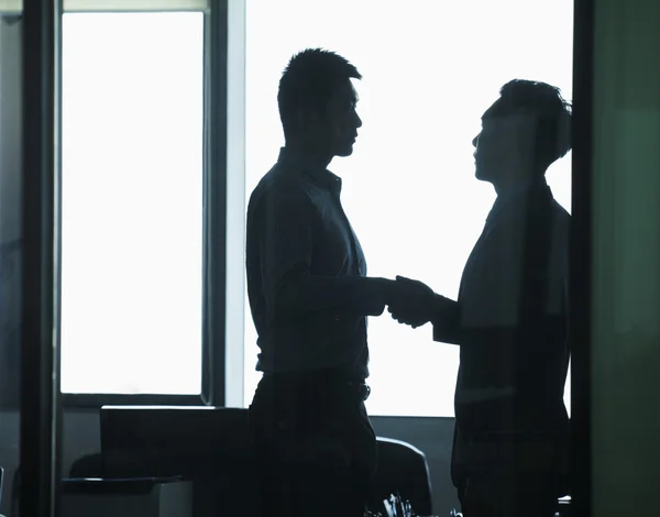 Businessmen shaking hands in office — Stock Photo, Image