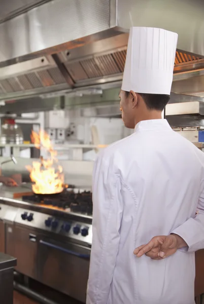 Chef con los dedos cruzados como una sartén se incendia — Foto de Stock