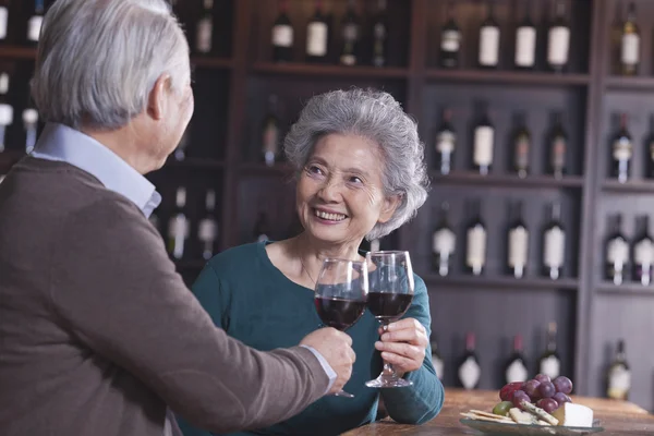 Seniorenpaar stößt an und trinkt Wein — Stockfoto