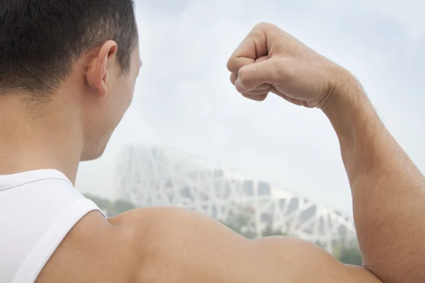 Young man flexing his bicep — Stock Photo, Image