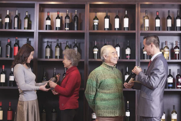 Människor undersöka vin på en vin butik — Stockfoto