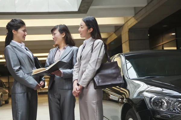 Businesswomen meeting and talking in parking garage — Stock Photo, Image