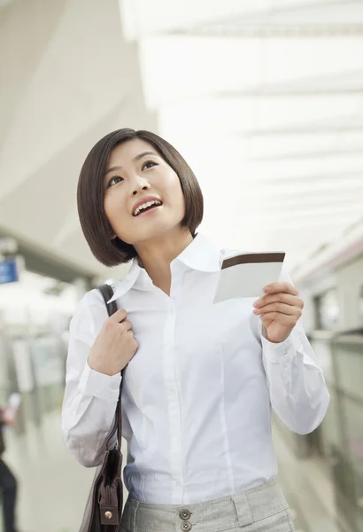 Женщина держит билет на поезд — стоковое фото