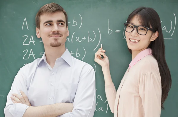 Students doing math formula on the chalkboard — Stock Photo, Image