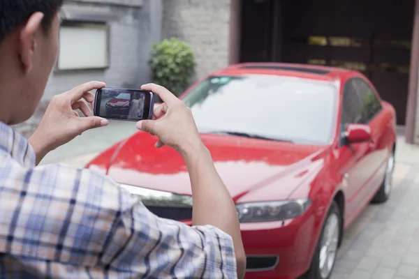 Jovem tirando uma foto de seu carro — Fotografia de Stock