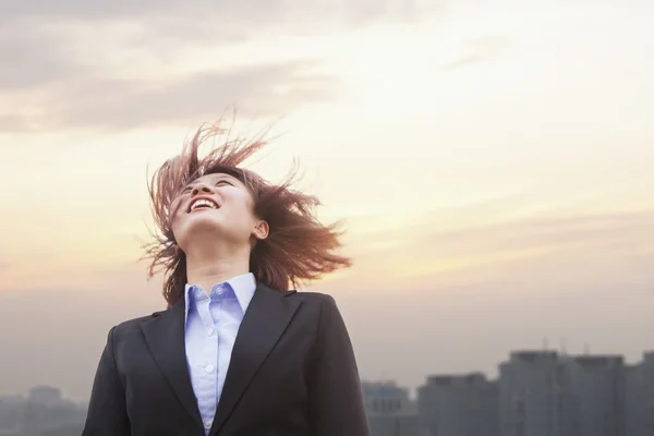 Empresária sorrindo com o cabelo soprando — Fotografia de Stock