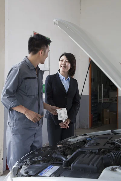 Mechaniker plaudert und lacht mit Kunde — Stockfoto