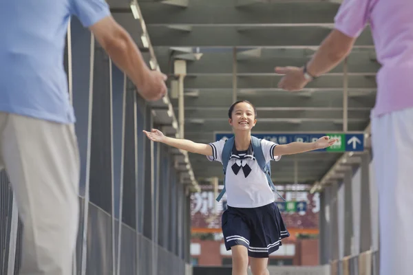 Granddaughter running towards her grandparents — Stock Photo, Image