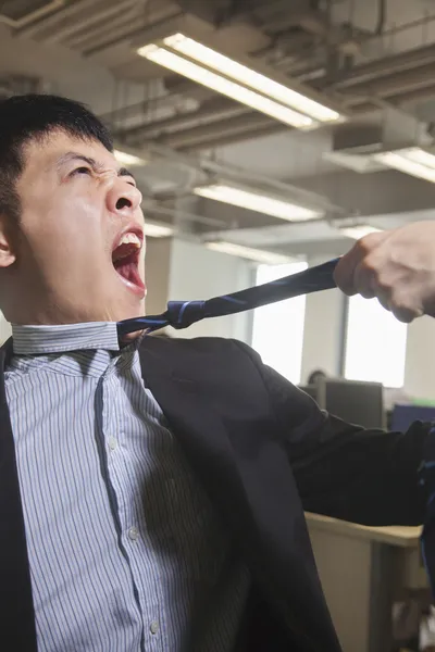 Бизнесмену выдернули галстук в офисе — стоковое фото