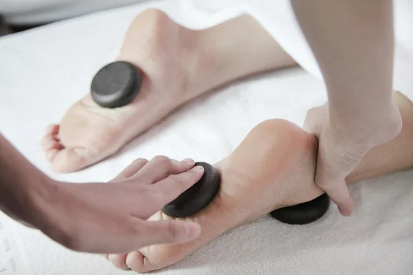 Vrouw ontvangende hete steen voet massage — Stockfoto