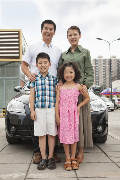 Family smiling in front of the car — Stock Photo, Image