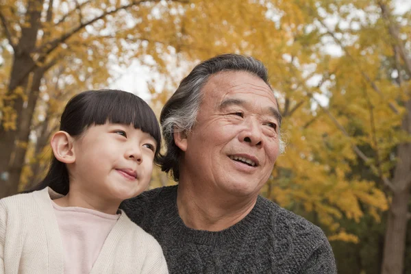 Grandfather and granddaughter in park — Stock Photo, Image