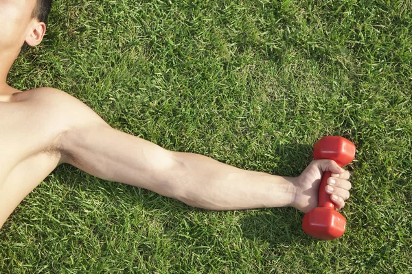 Arm and Shoulder Holding Dumbbell in Grass — Stock Photo, Image