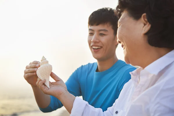 Oma en kleinzoon zeeschelp kijken — Stockfoto