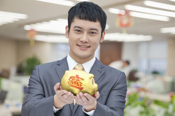 Business man holding Chinese piggy bank — Stock Photo, Image