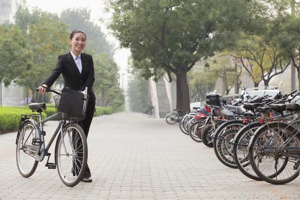 Businesswoman holding a bicycle — Stock Photo, Image