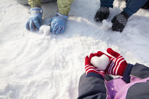Руки в зимние глотки, играющие в снегу Стоковое Изображение