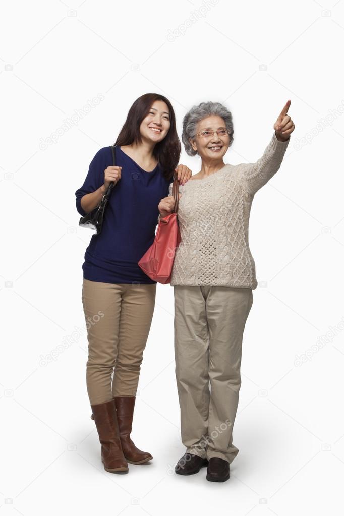 Senior mother and daughter pointing