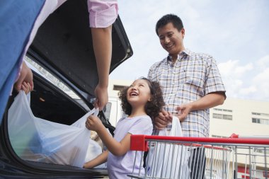 Aile yanında araba alışveriş torbaları ile konuşmak