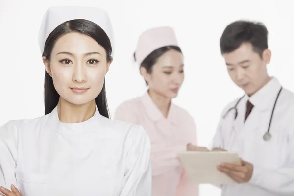 Young nurse, doctor and nurse in the background — Stock Photo, Image