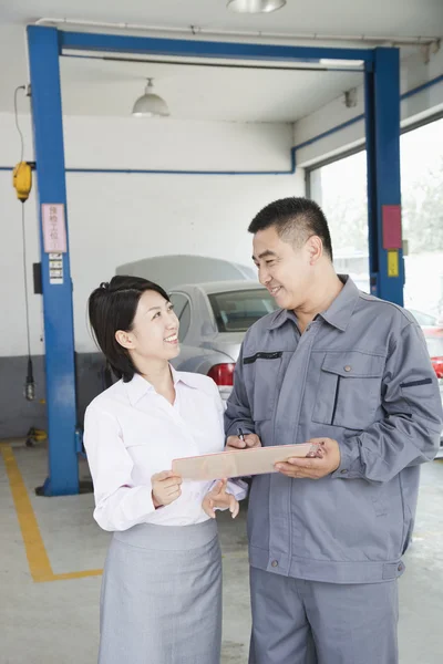 Mecánico de garaje explicando al cliente — Foto de Stock