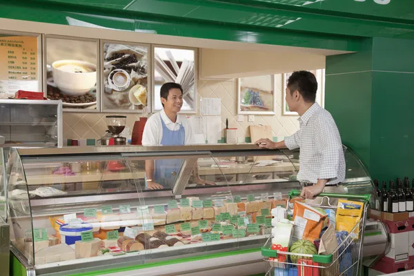 Sales Clerk assisting man at the Deli counter — Stock Photo, Image