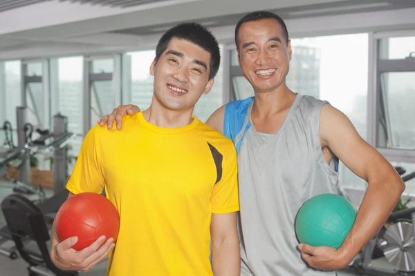 Two men holding balls in the gym — Stock Photo, Image