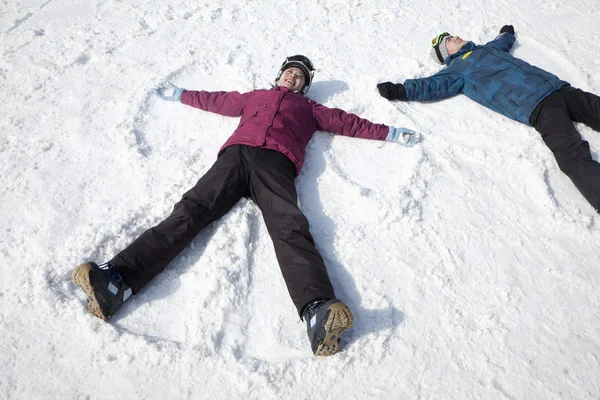 Homme et femme couchés sur la neige — Photo