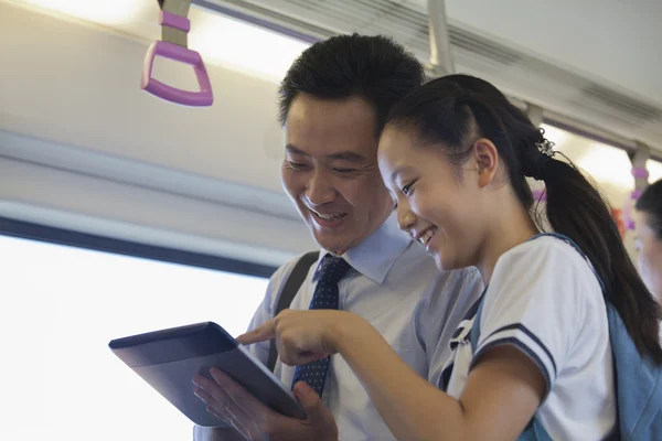 Father and daughter watching a movie in the subway — Stock Photo, Image