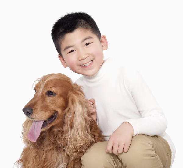 Pojken sitter bredvid sin hund — Stockfoto