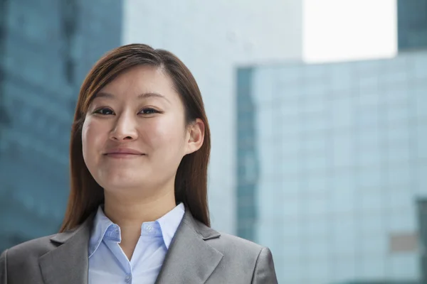 Businesswoman outdoors among skyscrapers — Stock Photo, Image
