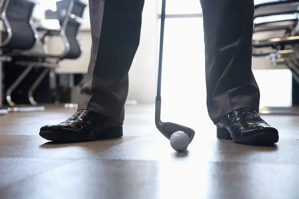 Empresário jogando golfe em seu escritório — Fotografia de Stock