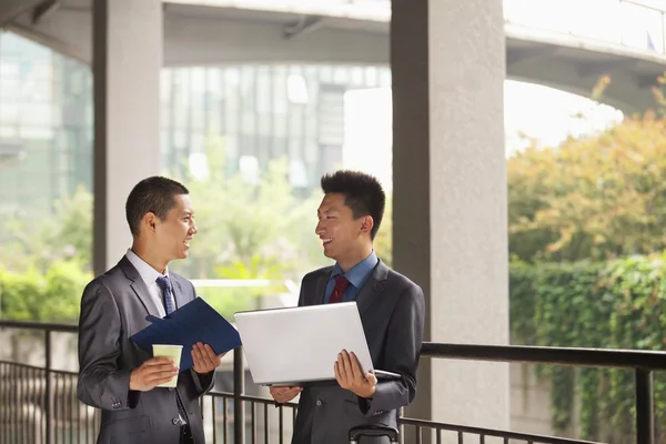 Businessmen working outdoor, looking at each other — Stock Photo, Image