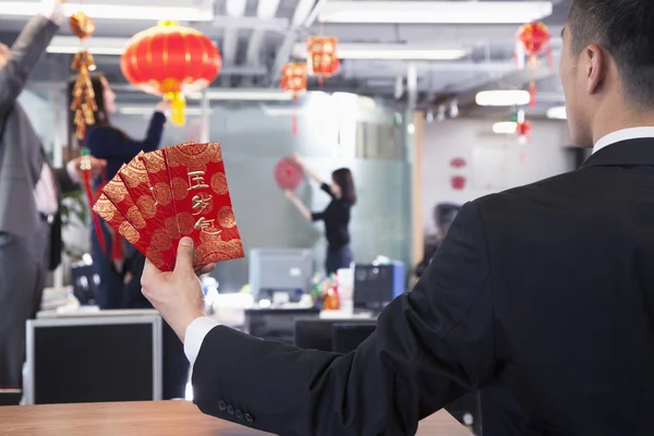 Zakenman bedrijf rode enveloppen — Stockfoto