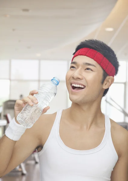 Hombre bebiendo de la botella de agua en el gimnasio —  Fotos de Stock