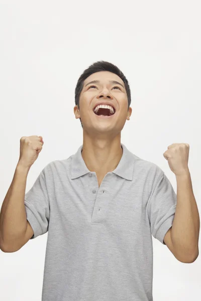 Enthusiastic young man with arms raised — Stock Photo, Image