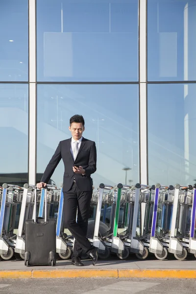 Traveler next to row of luggage carts — Stock Photo, Image